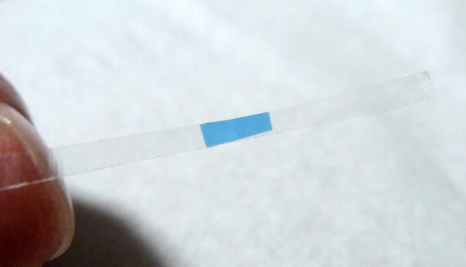 青い透明なシートを小さく切ってセロテープ、それらを細く切ってます